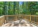 Wooden deck featuring new wood and providing a view of the surrounding lush greenery and trees at 5115 Leland Dr, Stone Mountain, GA 30083
