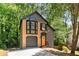 Two-story home with gray and beige brick facade and a built-in garage, framed by mature trees at 5115 Leland Dr, Stone Mountain, GA 30083