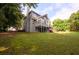 A view of the backyard featuring green grass, a treeline, a patio, and a wood deck at 620 Reeves Hill Pt, Lawrenceville, GA 30043