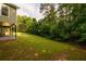 Backyard with luscious green grass, treeline, and walk-out basement patio at 620 Reeves Hill Pt, Lawrenceville, GA 30043