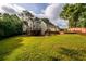 Wide angle of the large backyard with luscious green grass, treeline, deck, and patio at 620 Reeves Hill Pt, Lawrenceville, GA 30043