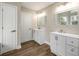 Bright bathroom featuring double vanities, modern fixtures and sleek wood-look flooring at 620 Reeves Hill Pt, Lawrenceville, GA 30043
