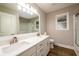 Bathroom with double vanity sink, quartz countertops, large mirror, tiled shower, and frosted window at 620 Reeves Hill Pt, Lawrenceville, GA 30043