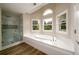 Bright bathroom showcasing a soaking tub, glass-enclosed shower and multiple windows at 620 Reeves Hill Pt, Lawrenceville, GA 30043