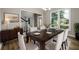 Formal dining room with a dark table, six chairs, and large window looking out on neighborhood at 620 Reeves Hill Pt, Lawrenceville, GA 30043