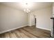 Well lit, large and neutral dining room features hardwood floors, and modern lighting fixture at 620 Reeves Hill Pt, Lawrenceville, GA 30043
