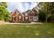 Charming two-story red brick home boasting a green lawn and manicured landscaping at 620 Reeves Hill Pt, Lawrenceville, GA 30043