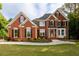 Stunning two-story red brick home featuring manicured lawn and lush landscaping at 620 Reeves Hill Pt, Lawrenceville, GA 30043