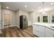 Contemporary kitchen with stainless steel refrigerator, island with breakfast bar, and access to the backyard at 620 Reeves Hill Pt, Lawrenceville, GA 30043
