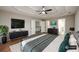 Comfortable main bedroom with tray ceiling, ceiling fan, TV, and ensuite bathroom at 620 Reeves Hill Pt, Lawrenceville, GA 30043