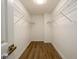 Clean, empty walk-in closet with open shelving and light wood-look flooring at 620 Reeves Hill Pt, Lawrenceville, GA 30043