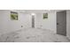 Bright bedroom featuring two windows with marble-look flooring, neutral white walls, and gray doors at 681 Fielding Sw Ln, Atlanta, GA 30311