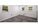 Bright bedroom featuring three windows with wood-look flooring and neutral white walls at 681 Fielding Sw Ln, Atlanta, GA 30311