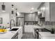 Modern kitchen featuring gray cabinetry, stainless steel appliances, and elegant marble countertops and backsplash at 681 Fielding Sw Ln, Atlanta, GA 30311