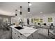 Open-concept living space with a kitchen island, modern lighting, and a view of the dining and living areas at 681 Fielding Sw Ln, Atlanta, GA 30311