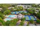 Aerial shot featuring tennis courts and a large community pool nestled among lush greenery at 7025 Kettering Ln, Suwanee, GA 30024