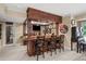 Basement bar area with wood bar, stools, tv and decor in finished basement at 7025 Kettering Ln, Suwanee, GA 30024