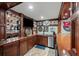 Basement bar area with wood cabinets, wine glasses, and stainless mini fridge at 7025 Kettering Ln, Suwanee, GA 30024