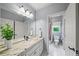 Well-lit bathroom featuring double sinks with granite countertops, a large mirror, and access to the shower at 7025 Kettering Ln, Suwanee, GA 30024