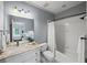 Bathroom with a vanity, sink, and a shower-tub combination, designed with modern fixtures and tiled walls at 7025 Kettering Ln, Suwanee, GA 30024