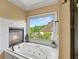 Spa-like bathroom with a soaking tub, fireplace, and natural light at 7025 Kettering Ln, Suwanee, GA 30024