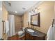 Bathroom with stone tile shower, tile floor, granite vanity, and decorative mirror at 7025 Kettering Ln, Suwanee, GA 30024
