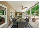 An expansive covered patio features an outdoor dining area with a ceiling fan and stone accents for elegant entertaining at 7025 Kettering Ln, Suwanee, GA 30024