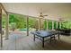 Large covered patio includes a ping pong table, outdoor dining area, and offers views of the inviting swimming pool at 7025 Kettering Ln, Suwanee, GA 30024