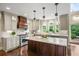 Gourmet kitchen with a center island, granite countertops, and modern appliances at 7025 Kettering Ln, Suwanee, GA 30024