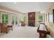 Open living room with fireplace, large windows, french doors, and shuffle board table at 7025 Kettering Ln, Suwanee, GA 30024
