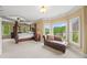Spacious main bedroom with a sitting area, four-poster bed, and tray ceiling at 7025 Kettering Ln, Suwanee, GA 30024