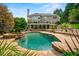 Backyard oasis with a luxurious pool, rock features, and lush landscaping at 7025 Kettering Ln, Suwanee, GA 30024