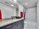 Modern bathroom featuring granite countertops, a sleek vanity, and a tiled shower with hexagonal pattern at 860 Peachtree Ne St # 1502, Atlanta, GA 30308