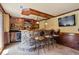 A home bar featuring stone accents, wooden cabinets, and stylish barstool seating at 4250 Old Oak Trce, Cumming, GA 30041