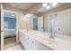 Modern bathroom with double vanity, white cabinets, and separate doorway to blue bedroom at 4250 Old Oak Trce, Cumming, GA 30041