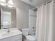 Neutral bathroom with white vanity, toilet, shower-tub with white shower curtain, and a mirror at 4250 Old Oak Trce, Cumming, GA 30041
