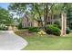 Stately brick home with a well-kept lawn, mature trees and a long driveway at 4250 Old Oak Trce, Cumming, GA 30041