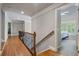 Bright hallway featuring hardwood floors, elegant railings, and an open doorway to a bedroom at 4250 Old Oak Trce, Cumming, GA 30041