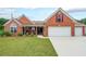 Charming brick home featuring a manicured lawn, inviting front porch, and an attached two-car garage at 1382 Fountain Lakes Drive Dr, Lawrenceville, GA 30043