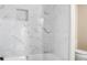 Modern bathroom tub-shower combo with marble tile, built-in niche, and sleek fixtures at 3210 Quincetree Lane Ln, Decatur, GA 30034