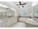 Luxurious bathroom with granite countertops, elegant cabinetry, soaking tub, and decorative stained glass window at 10630 N Edgewater Pl, Johns Creek, GA 30097