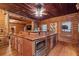 Rustic log cabin kitchen featuring custom wood cabinetry and modern stainless steel appliances at 10630 N Edgewater Pl, Johns Creek, GA 30097