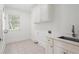 Practical laundry room with ample cabinet space, a sink, and a window for natural light at 10630 N Edgewater Pl, Johns Creek, GA 30097