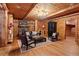 Living room with stone fireplace, wood walls, hardwood floors, and seating area at 10630 N Edgewater Pl, Johns Creek, GA 30097