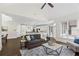 Bright living room with a dark sofa, vaulted ceiling, adjacent to a large kitchen, and large sunlit windows at 10630 N Edgewater Pl, Johns Creek, GA 30097