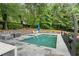 Backyard featuring a pristine in-ground swimming pool surrounded by a stone patio and lush landscaping at 10630 N Edgewater Pl, Johns Creek, GA 30097