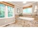 Bathroom features a soaking tub, tile surround, and natural lighting at 2786 Overlook Ne Dr, Atlanta, GA 30345