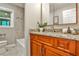 Bathroom featuring cherry vanity, granite countertops, and a shower-tub combo at 2786 Overlook Ne Dr, Atlanta, GA 30345