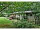 Back of the house featuring mature trees, lush greenery, and a well-maintained lawn at 2786 Overlook Ne Dr, Atlanta, GA 30345