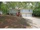 Charming split-level home featuring a spacious front yard, two-car garage, and inviting red stairway entrance at 4191 Alaina Cir, Austell, GA 30106